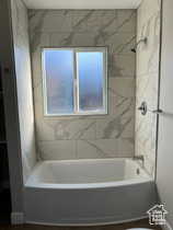 Bathroom with tub / shower combination and dark wood finished floors