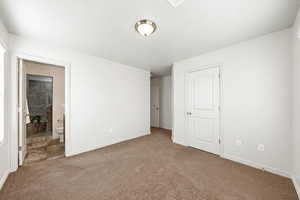 Unfurnished bedroom featuring carpet floors and ensuite bathroom