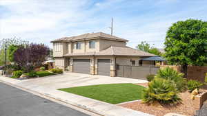 View of front facade with stucco siding, concrete driveway, stone siding, a tiled roof, and an attached garage