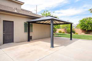 Fenced backyard featuring a gazebo and a patio