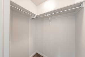 Walk in closet featuring dark carpet