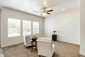 Sitting room with ceiling fan, recessed lighting, and carpet