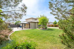 Rear view of property with a fenced backyard, stucco siding, a patio area, and a gazebo