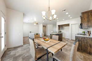 Dining space featuring suspended lighting, stone finish floors, and ceiling fan