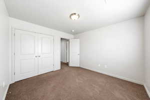 Unfurnished bedroom with carpet flooring and a closet