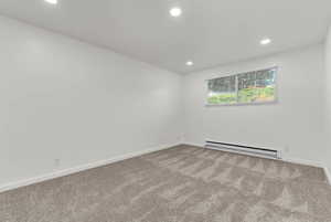 Carpeted spare room with baseboard heating and recessed lighting