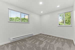 Spare room featuring baseboard heating, carpet floors, and recessed lighting