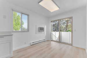 Spare room featuring light wood-style floors and a baseboard heating unit