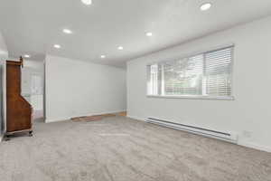 Carpeted empty room with a baseboard radiator and recessed lighting