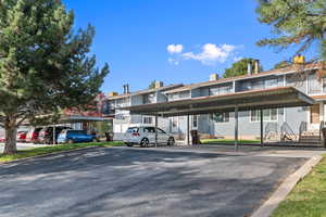 View of building exterior featuring covered parking