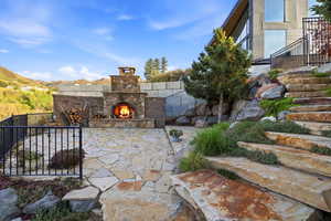 View of patio / terrace with an outdoor stone fireplace and a mountain view