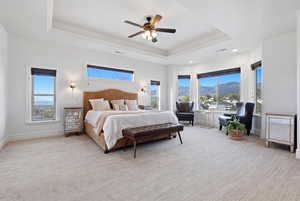 Bedroom featuring light carpet, a mountain view, ceiling fan, a raised ceiling, and recessed lighting