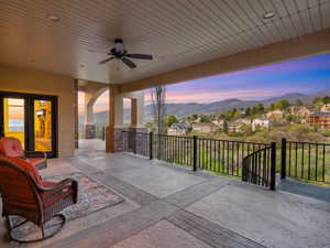 Patio terrace at dusk featuring ceiling fan, a residential view, a mountain view, and a patio