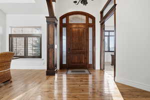 Entrance foyer with arched walkways, light wood-style flooring, and healthy amount of natural light