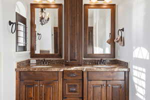Full bathroom featuring double vanity and tasteful backsplash