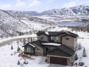 View of front of property featuring stone siding, driveway, and a mountain view