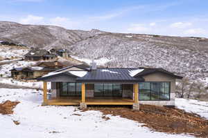 View of front facade with a standing seam roof and a deck with mountain view