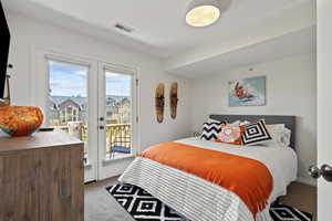 Bedroom featuring french doors, light carpet, and access to outside deck