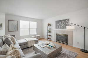 Living room featuring light wood-style floors and a fireplace