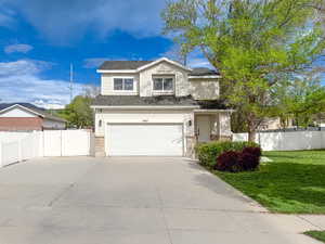 Traditional-style home featuring a gate, concrete driveway, and an attached garage