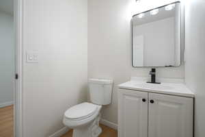 Half bathroom featuring vanity and light wood finished floors