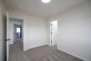 Spare room with dark carpet and baseboards