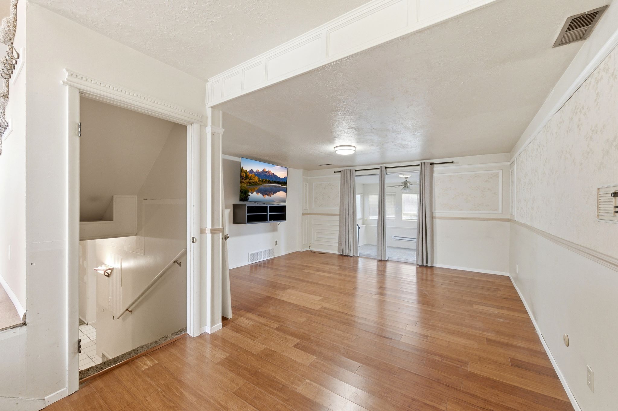 Empty room with a textured ceiling and light wood-style floors