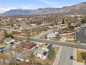 Aerial view of property and surrounding area with mountains and nearby suburban area