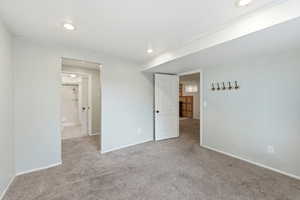 Unfurnished bedroom with light colored carpet and recessed lighting