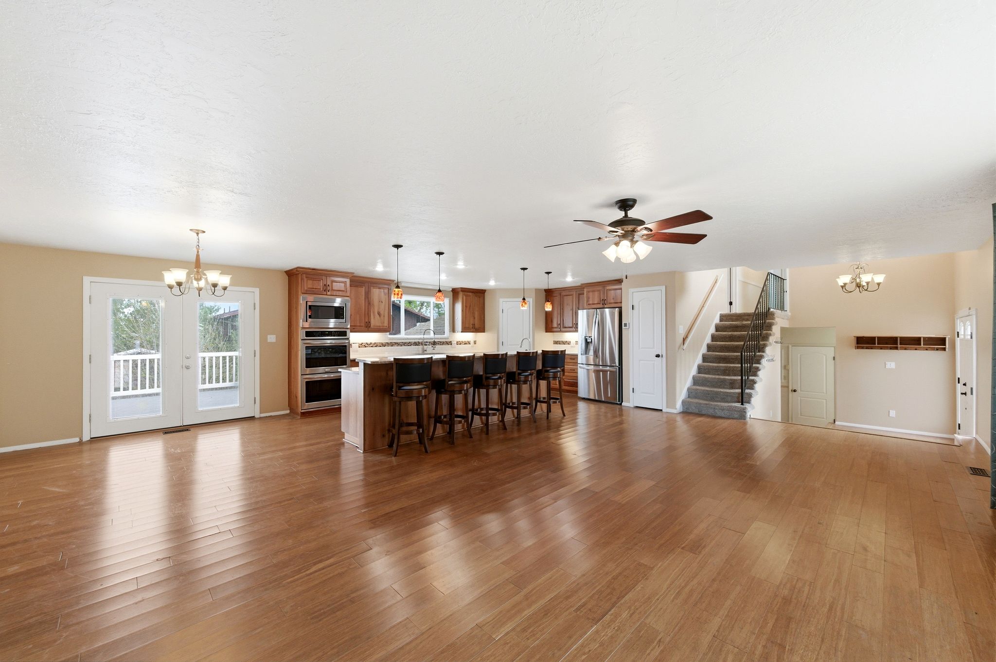 Living area with hanging lights, dark wood-style floors, and a ceiling fan