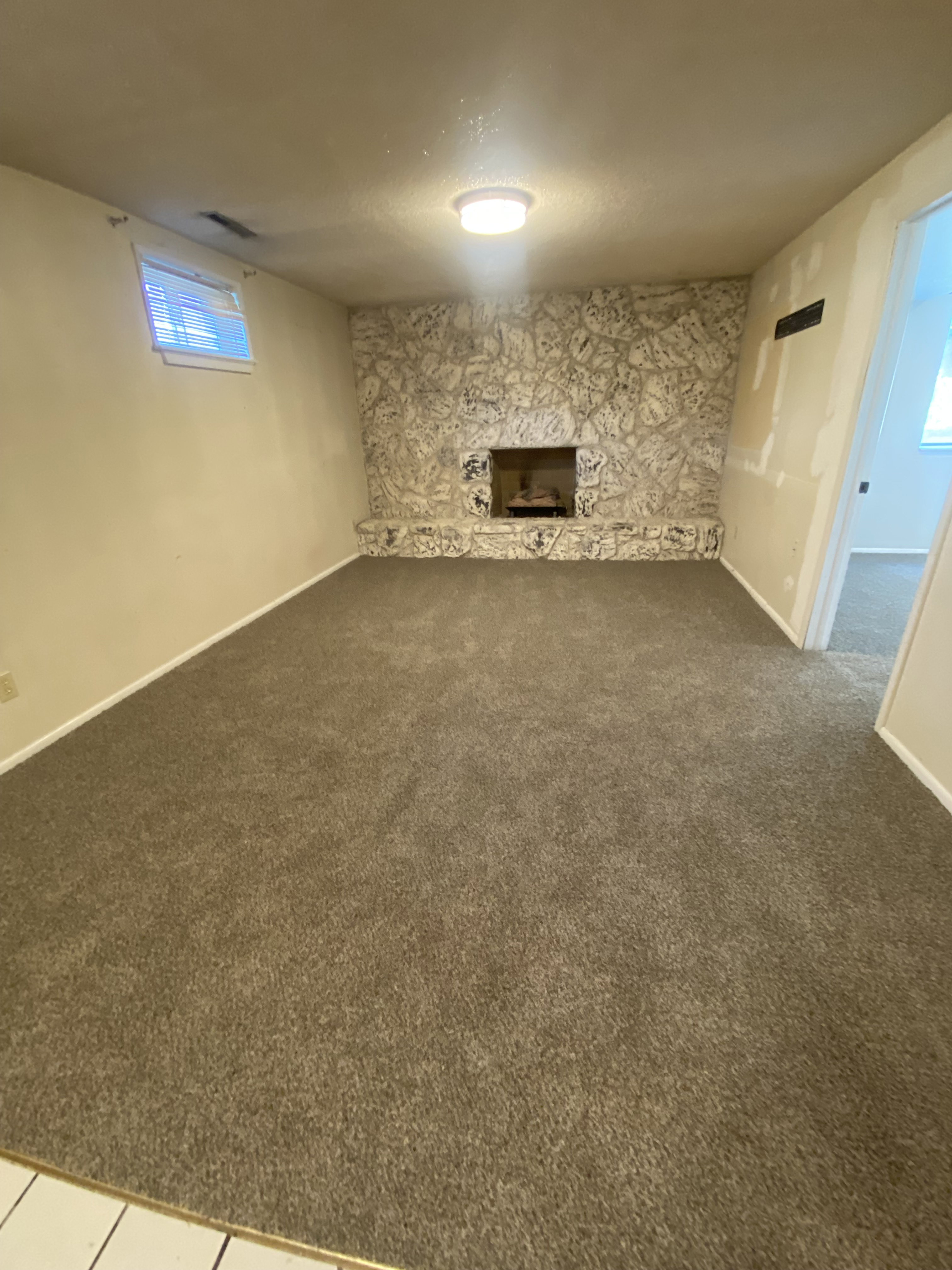 Interior space featuring a stone fireplace, recessed firebox, and a stone hearth