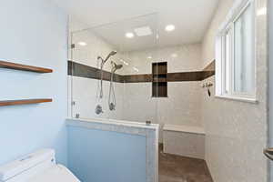 Full bath featuring a walk in shower and unfinished concrete flooring