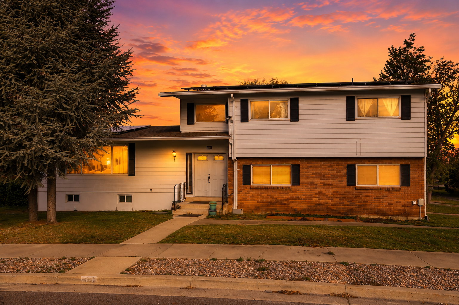 Split-level residence featuring a brick and siding exterior