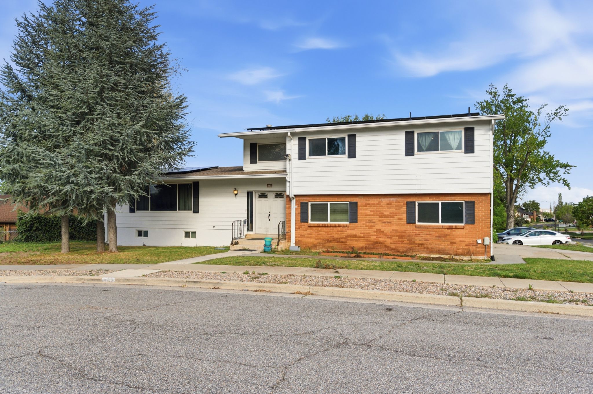 Tri-level home featuring solar panels and brick siding