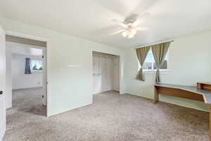 Unfurnished bedroom featuring light colored carpet, a closet, ceiling fan, and multiple windows