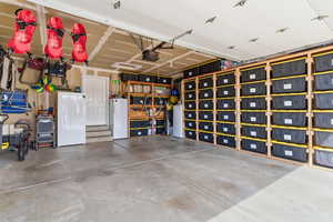 Garage featuring freestanding refrigerator and a garage door opener
