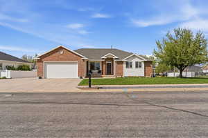 Ranch-style house with concrete driveway, an attached garage, brick siding, and roof with shingles