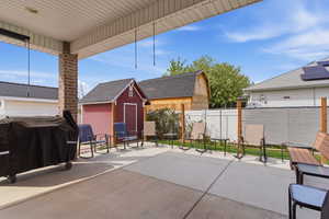View of patio / terrace featuring area for grilling and a storage unit