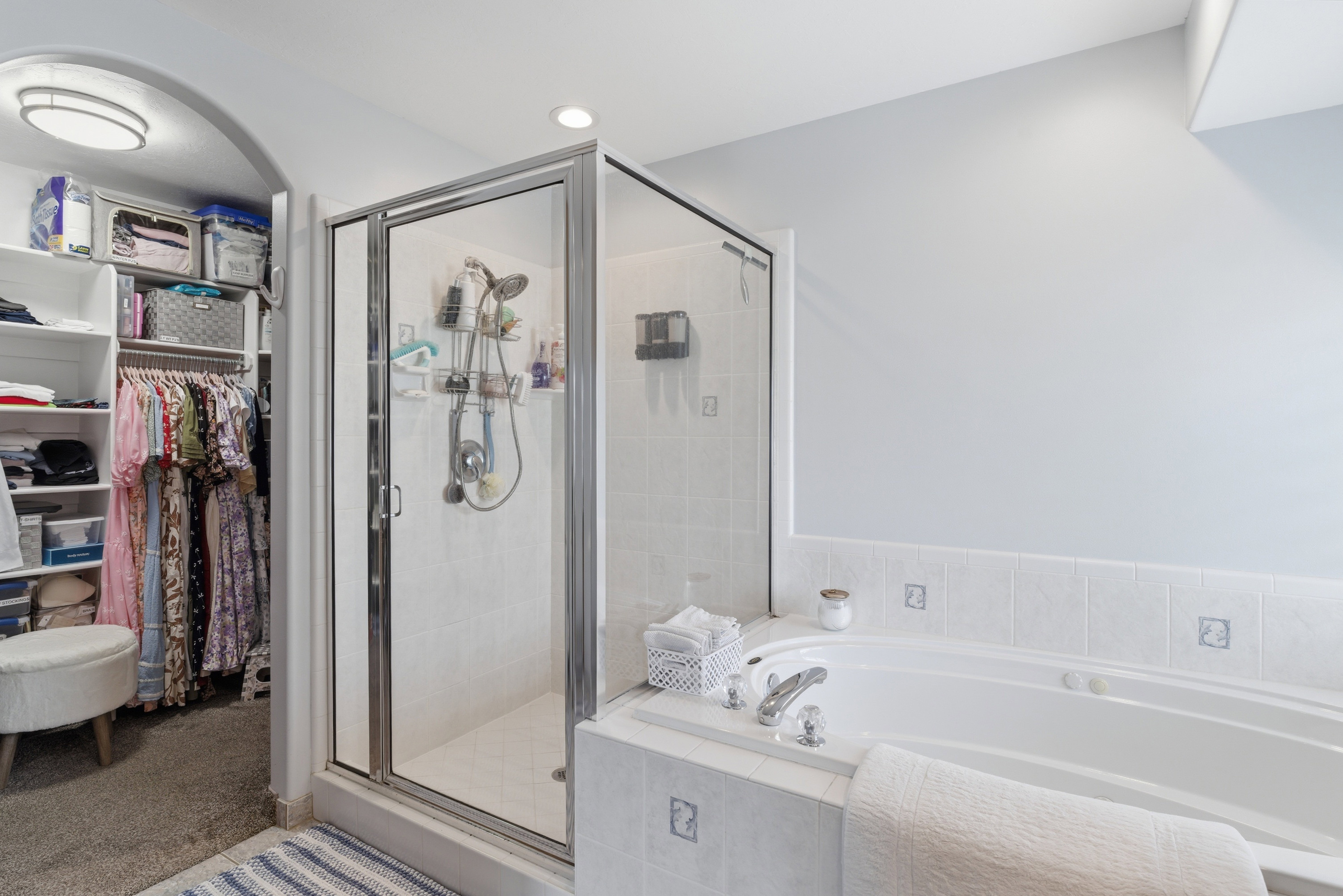 Full bath with a garden tub, a shower stall, and a spacious closet