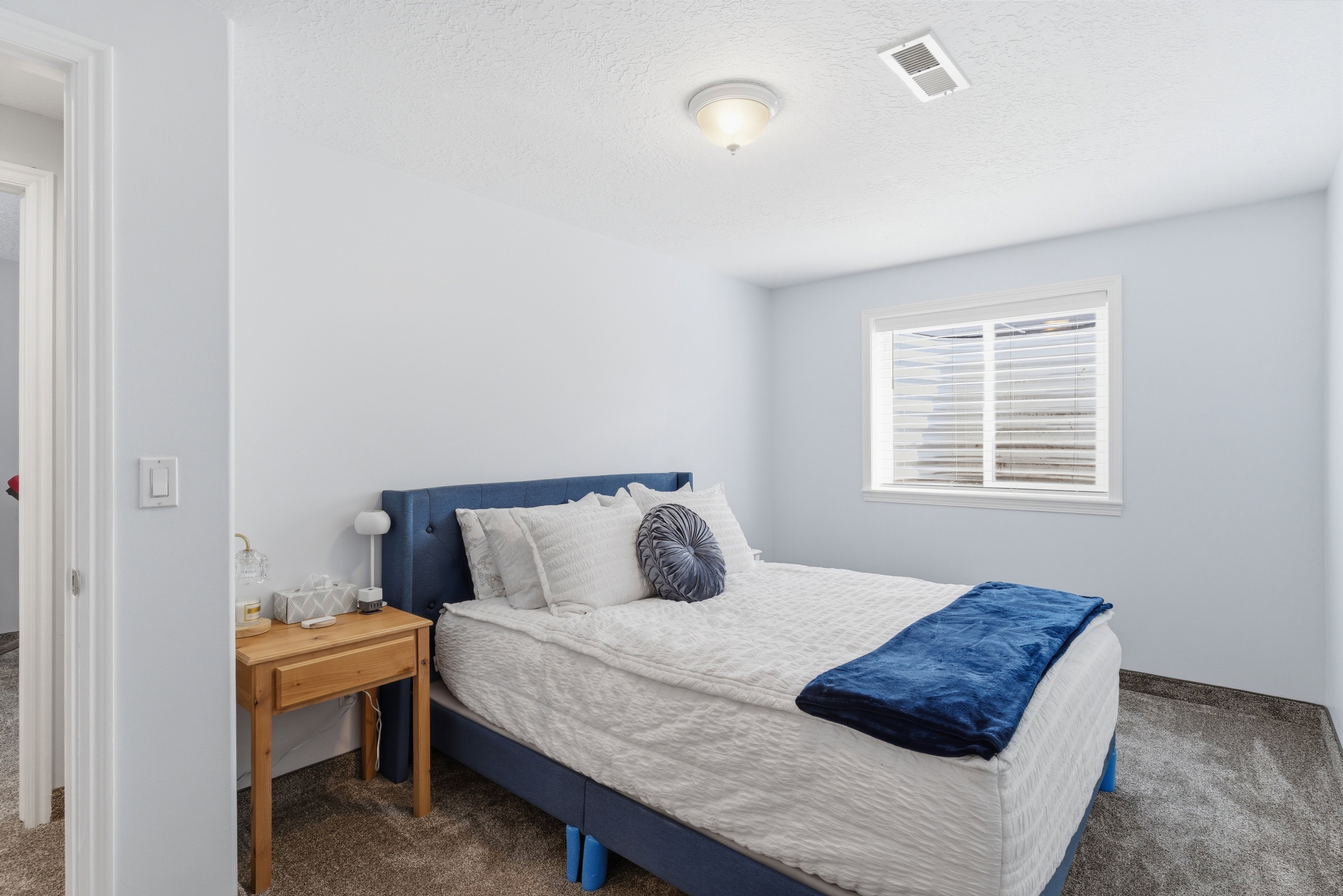 Bedroom with dark colored carpet and a textured ceiling