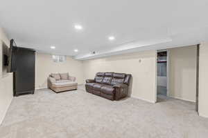 Living area with light carpet and recessed lighting