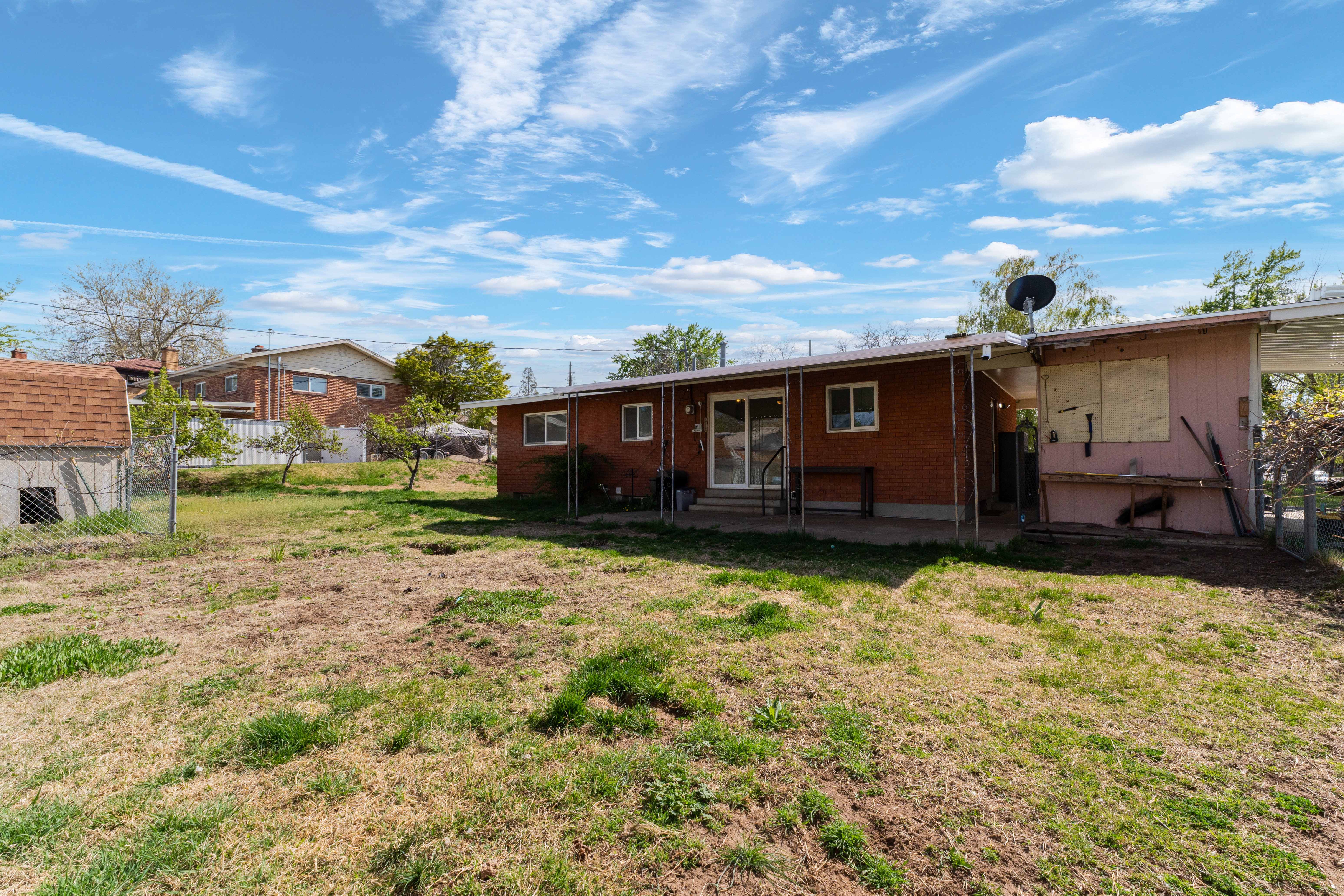 Rear view of house featuring a patio area, entry steps, and brick siding