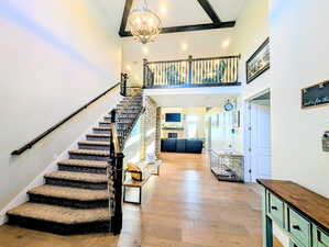 Staircase featuring a fireplace, hardwood / wood-style flooring, and a chandelier