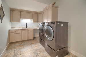 Laundry room with washer and dryer, light stone finish flooring, and cabinet space