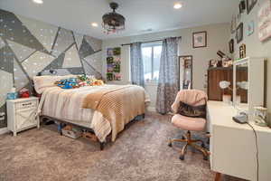 Carpeted bedroom with an accent wall, recessed lighting, and a desk