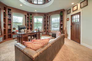 Home office featuring built in shelves, carpet, healthy amount of natural light, and recessed lighting