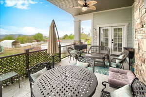 Balcony featuring a ceiling fan, french doors, and an outdoor living / dining area