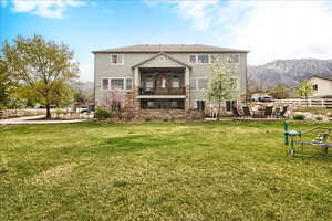 Back of property with a patio, a balcony, a mountain view, ceiling fan, and brick siding
