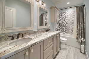 Full bath featuring double vanity, shower / bath combo, and recessed lighting