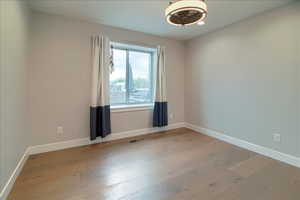 Unfurnished room with light wood-style flooring and baseboards
